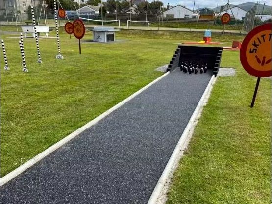 The skittles alley with pins set up at the end of the lane